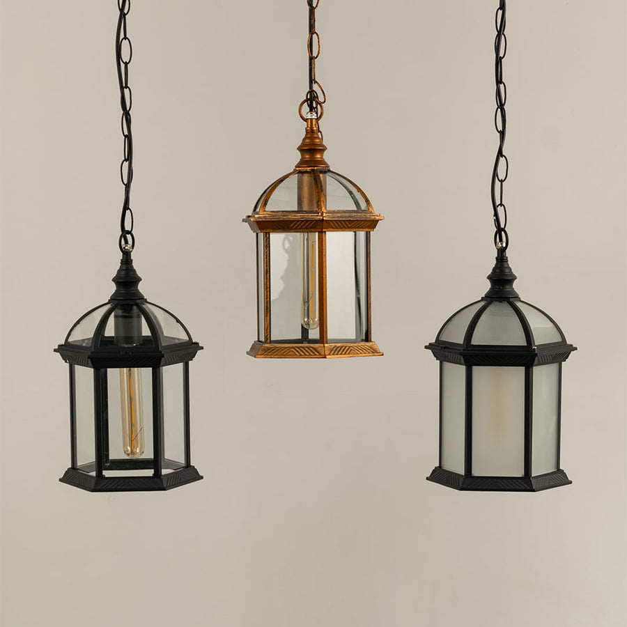 Grouped hanging lanterns with light off showing bronze and black frames dome tops and clear glass panels suitable for classic themed outdoor decor.