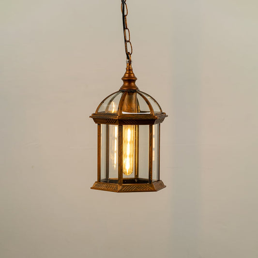 Bronze hanging outdoor lantern on white background with light on displaying warm illumination through clear glass panels and vintage dome top design.