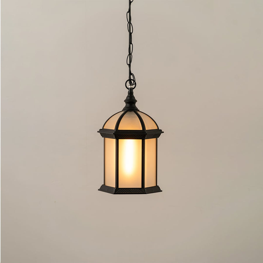 Black vintage hanging lantern on white background with light on showing warm frosted glow and classic dome top design ideal for exterior ceiling lighting.