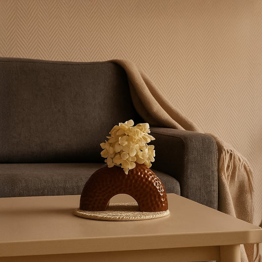 Lifestyle image showcasing a brown arched ceramic vase with a textured finish styled in a clean setting for a modern decorative look.
