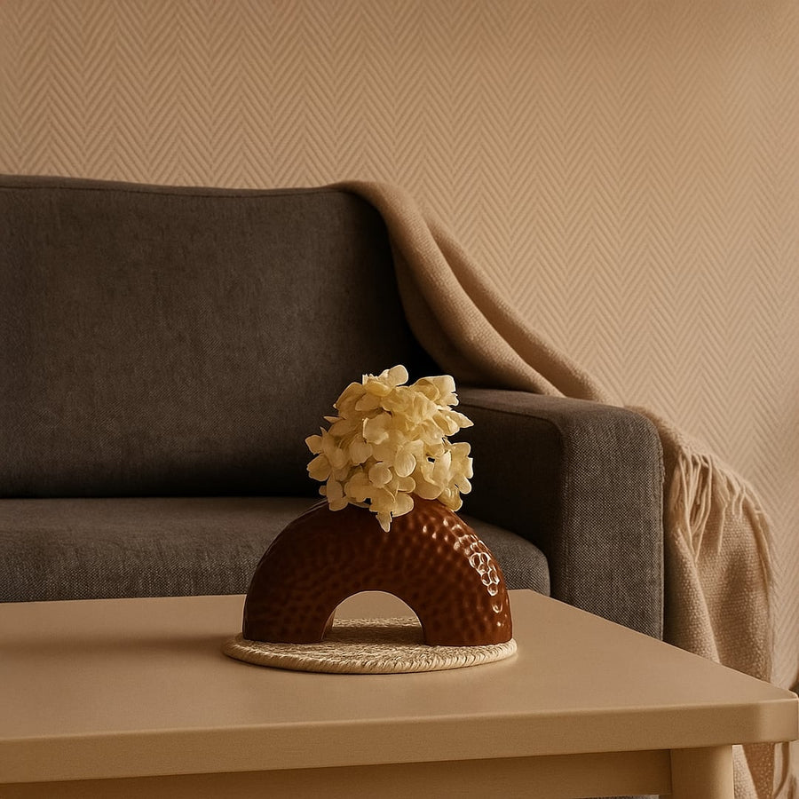 Lifestyle image showcasing a brown arched ceramic vase with a textured finish styled in a clean setting for a modern decorative look.