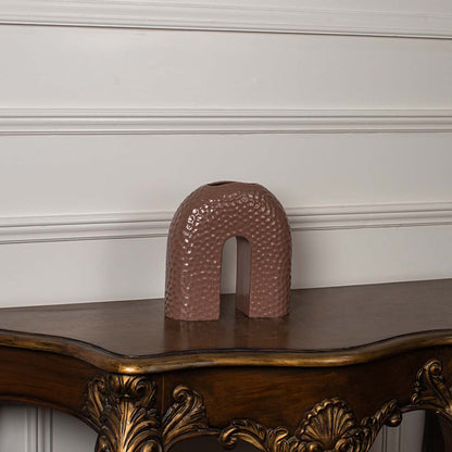 Brown arched ceramic vase displayed on a clean white background showing its smooth shape and textured finish.