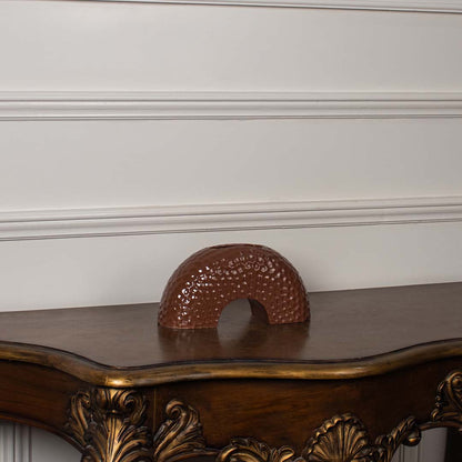 Brown arched ceramic vase displayed on a clean white background  showing its textured surface and curved modern silhouette clearly.