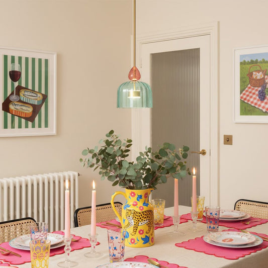 Turquoise glass pendant light with coral accents enhancing dining room decor with playful modern charm.