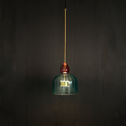 Illuminated turquoise glass pendant light with coral accents creating warm ambiance for elegant spaces.