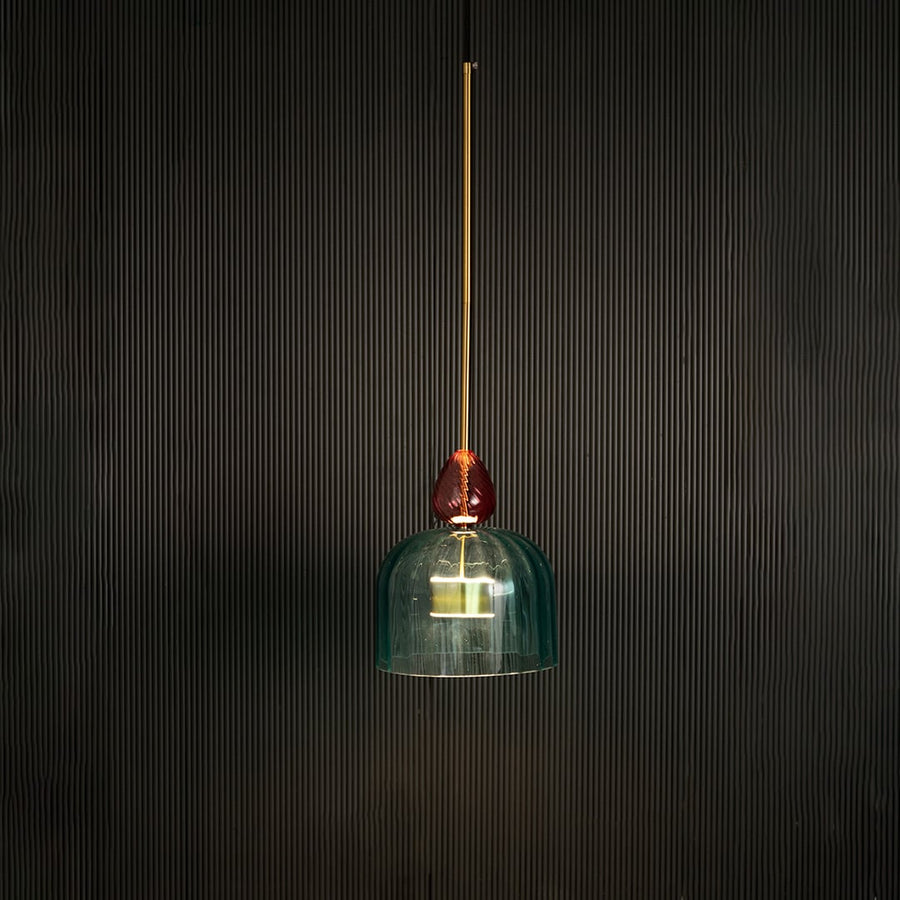 Illuminated turquoise glass pendant light with coral accents creating warm ambiance for elegant spaces.