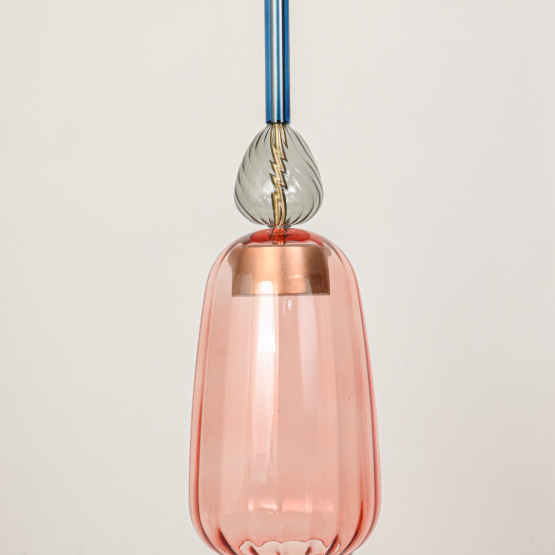 Detailed view of pink glass pendant light with transparent finish and refined decorative accents.