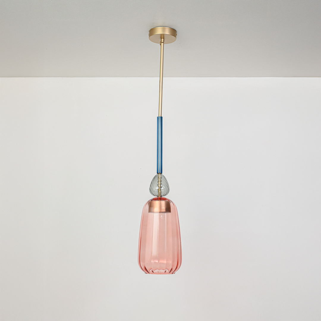 Pink glass pendant light with blue stem and gold fittings designed for contemporary interiors.