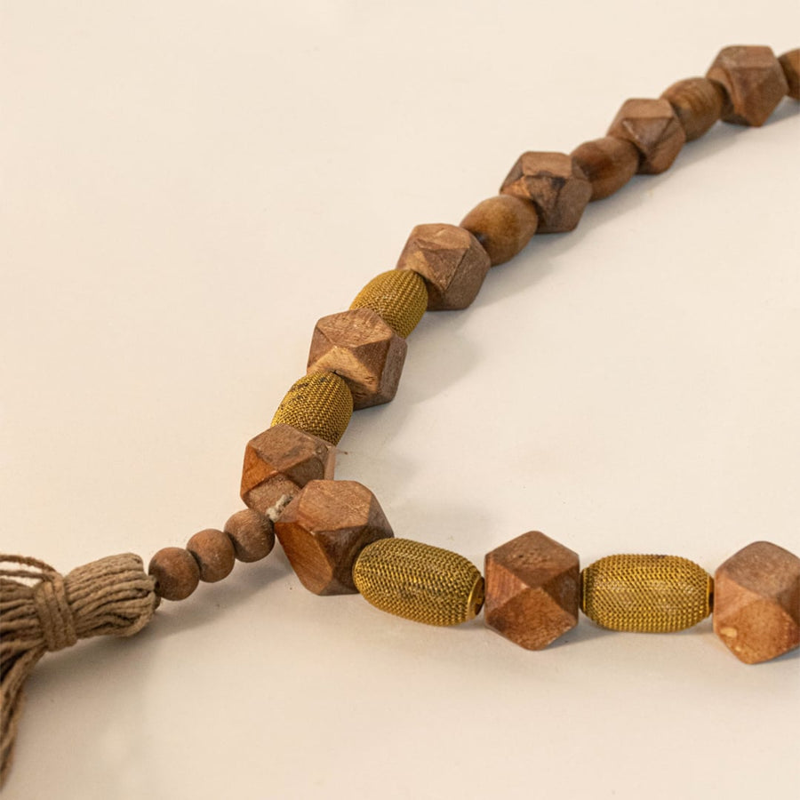 Close-up shot of brown bead garland showing the wooden bead texture and hand-tied tassel craftsmanship.