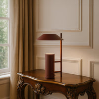 Terracotta brown metal table lamp with geometric shade adding modern elegance to tabletop decor in a stylish living room setting.