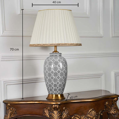 Grey patterned table lamp with gold base displayed with measurements showing 70 cm height and 40 cm shade width on a white panelled wall.