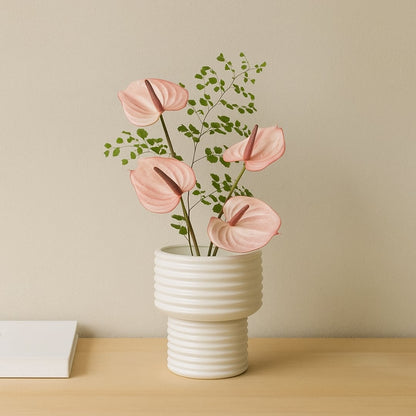 White ribbed ceramic vase styled in a modern interior perfect for consoles shelves and elegant minimal home decor accents.