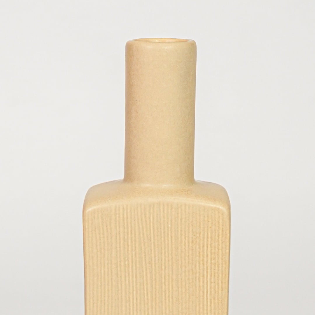 Yellow ceramic flower vase closeup with ribbed texture modern decorative vase for shelf console table home decor styling.