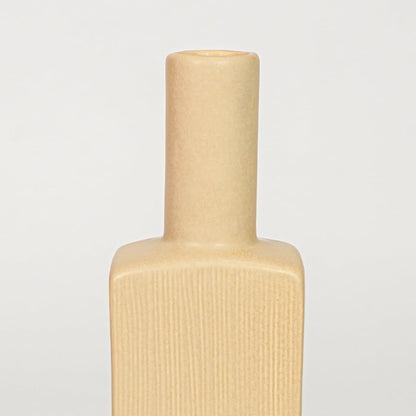 Yellow ceramic flower vase closeup with ribbed texture modern decorative vase for shelf console table home decor styling.
