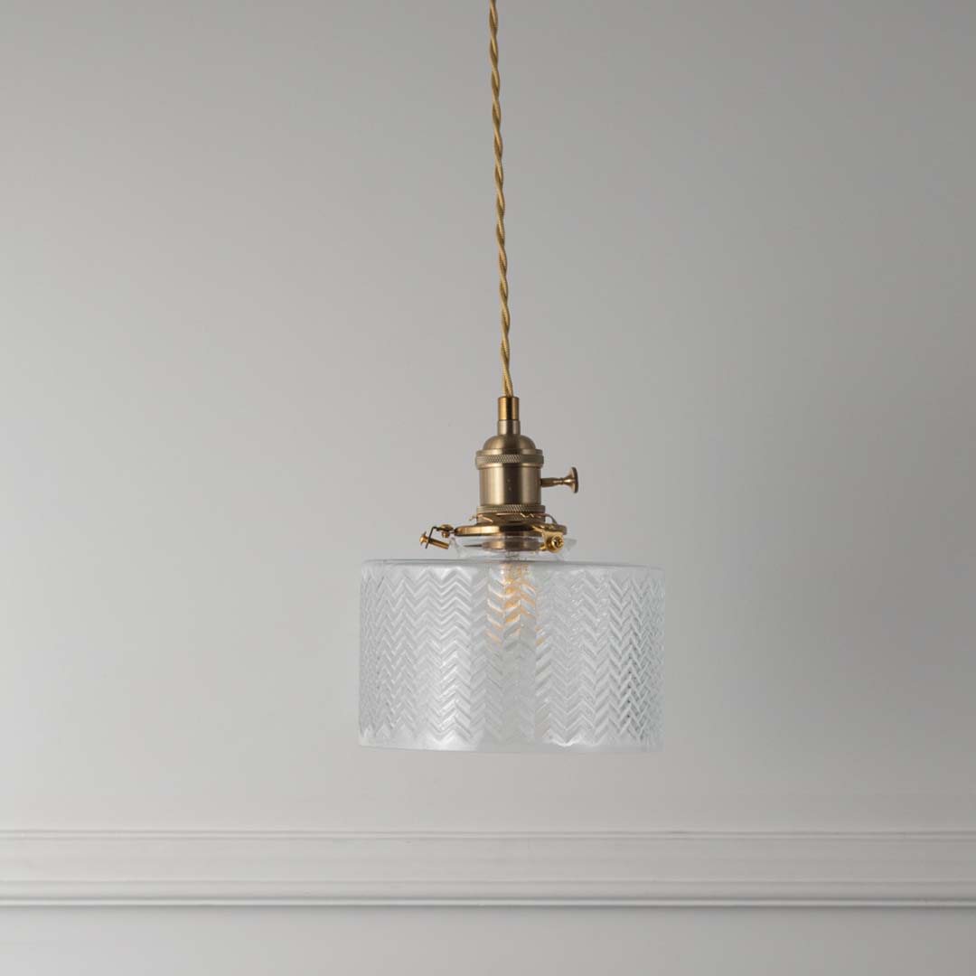 Textured clear glass and brass metal pendant light with vintage styling for refined home interiors.