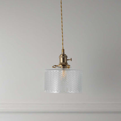 Textured clear glass and brass metal pendant light with vintage styling for refined home interiors.
