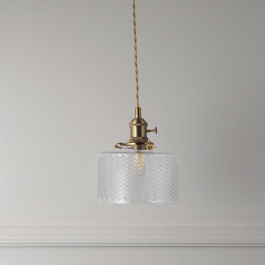 Textured clear glass and brass metal pendant light with vintage styling for refined home interiors.