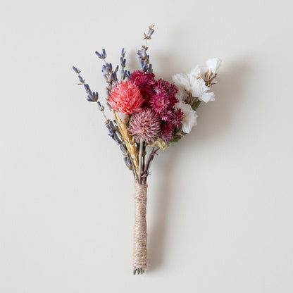 Dried floral stem bouquet with lavender wheat and pink blooms on white background highlighting layered textures handcrafted charm and decor appeal.