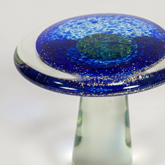 Close up view blue art glass mushroom decor object showing glossy texture handmade glass finish luxury accent for shelf styling home.