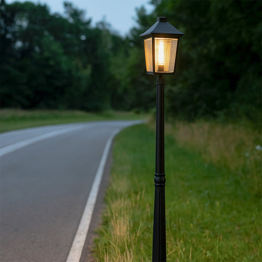 Traditional black metal post lamp standing tall in outdoor garden setting creating vintage street light ambiance and charm.