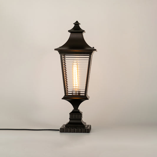 Vintage black outdoor gate light with glowing bulb for elegant exterior decor styling use.