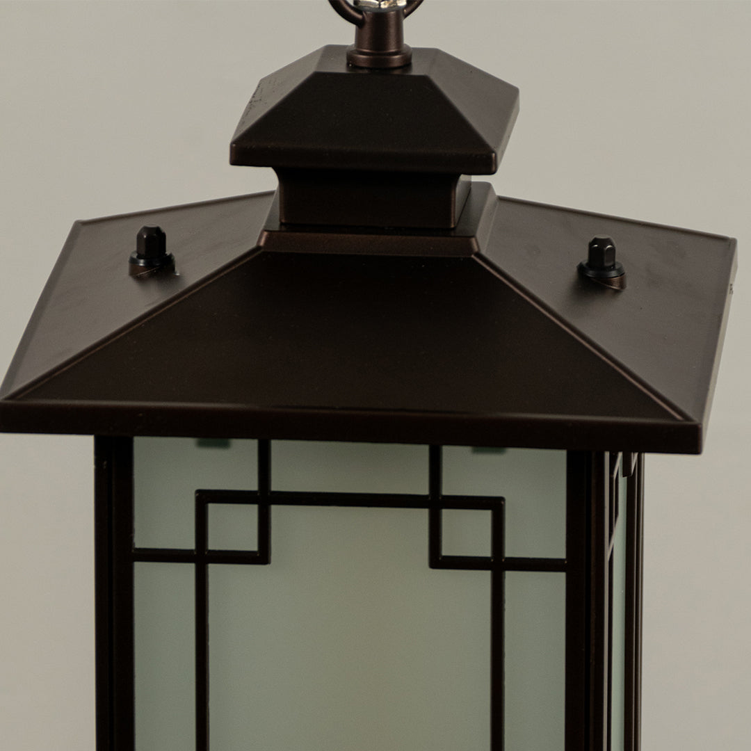 Closeup of black metal outdoor lantern with glass panels on white background ideal for gate entrance and exterior decor lighting.