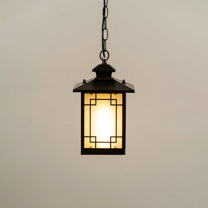 Black hanging lantern on white background with light on displaying glowing frosted glass geometric metal frame and compact design ideal for porches and patios.