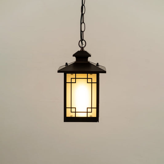 Black hanging lantern on white background with light on displaying glowing frosted glass geometric metal frame and compact design ideal for porches and patios.