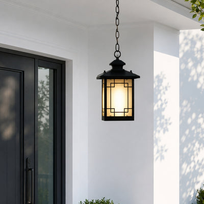 Modern black metal and glass outdoor hanging lantern for porch entrance patio and covered balcony with warm lighting.