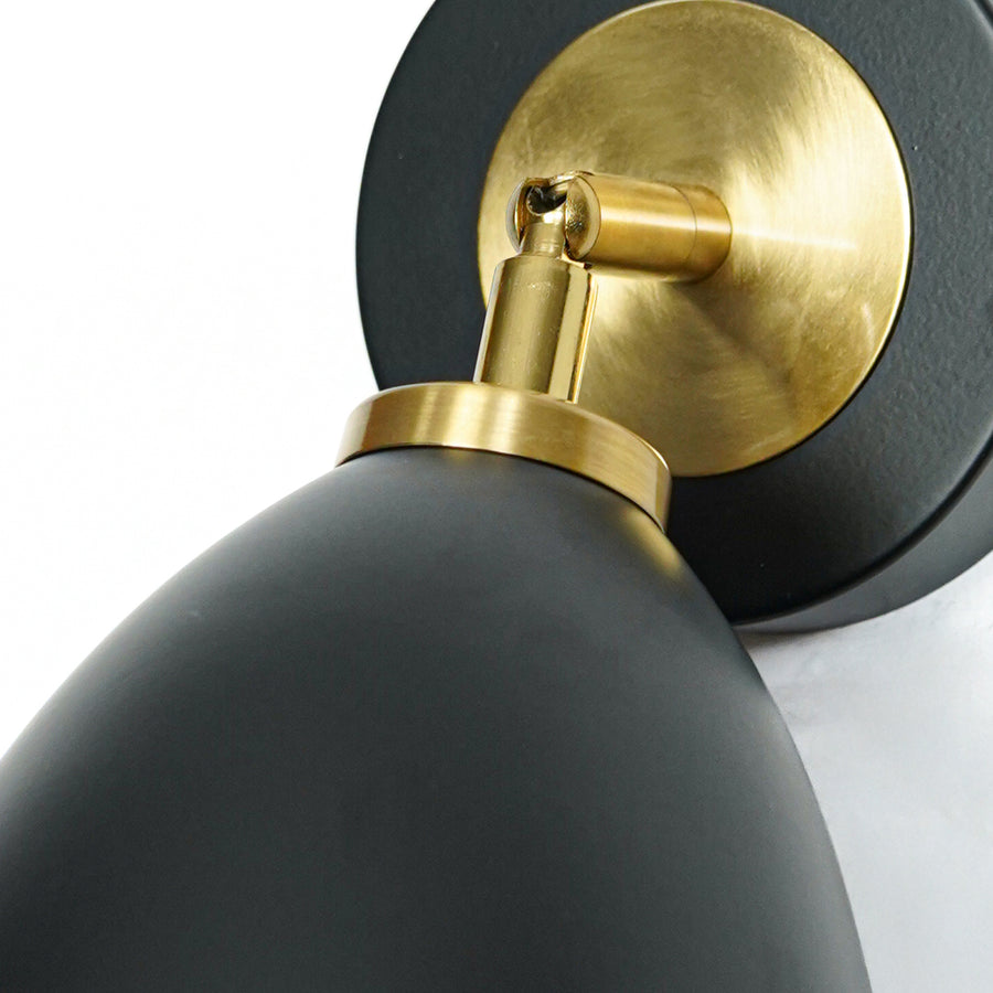 Closeup of black and gold metal wall light base for luxury bedroom hallway and modern interior decor styling.