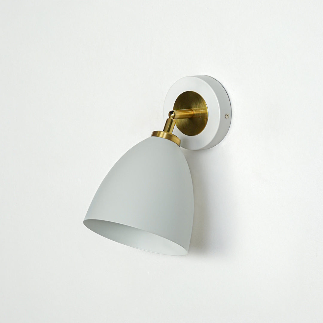 Elegant white and gold metal wall light with cone shade for stylish modern bedroom and hallway decor styling.