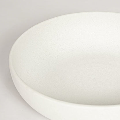 Closeup of matte white ceramic bowl with minimalist round shape ideal for elegant home decor shelf styling.