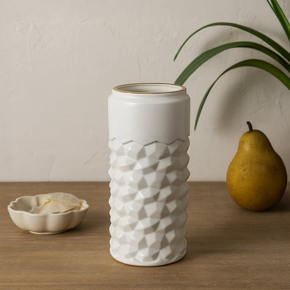 White textured ceramic vase with gold rim styled on a soft minimal background creating a modern decorative accent for shelves and consoles.