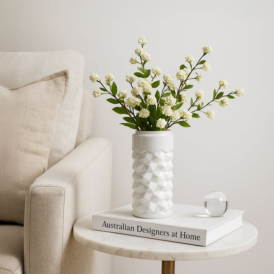 White textured ceramic vase styled in a soft minimal setting adding a modern accent to shelves and tables for elegant home decor.