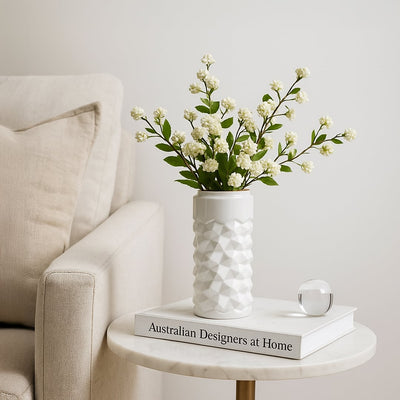 White textured ceramic vase styled in a soft minimal setting adding a modern accent to shelves and tables for elegant home decor.