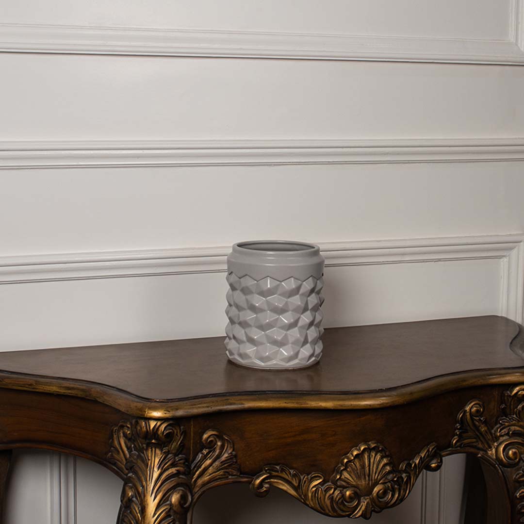 Grey geometric ceramic vase placed on a plain white background highlighting its textured pattern for a clean modern decor style.