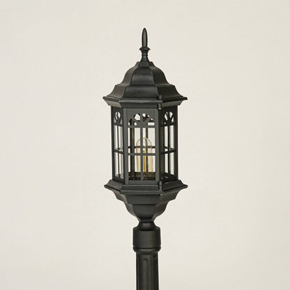 Close view of black outdoor lantern pole light with glass enclosure showcasing durable weather resistant exterior lighting design.