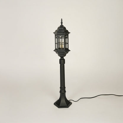 Traditional outdoor pole light with decorative lantern top and black metal body on clean background ideal for garden or patio lighting.
