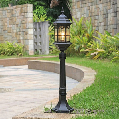 Black outdoor garden pole light with classic lantern design installed along curved pathway in landscaped garden ideal for pathway lighting.