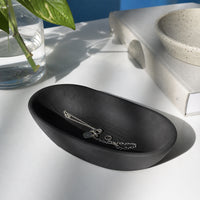 Black textured ceramic decorative tray placed on table for elegant contemporary home decor styling.