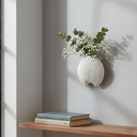 White resin wall hook mounted beside a wooden shelf for hanging decor in living room bedroom or entryway interiors.