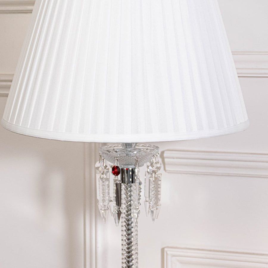 Closeup of glass lamp showing crystal body chrome detailing and pleated white fabric shade for modern home decor.