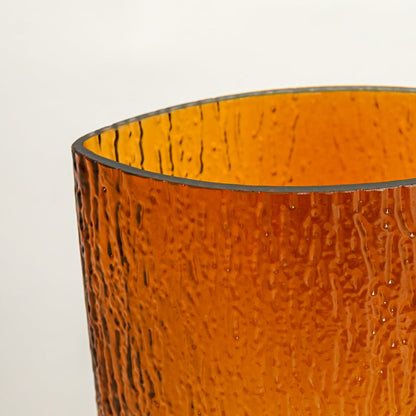 Close up view amber textured glass vase showing hammered surface glossy finish decorative glass accent for modern home styling.