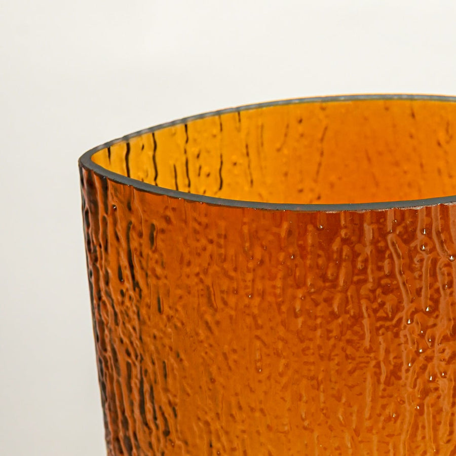 Close up view amber textured glass vase showing hammered surface glossy finish decorative glass accent for modern home styling.
