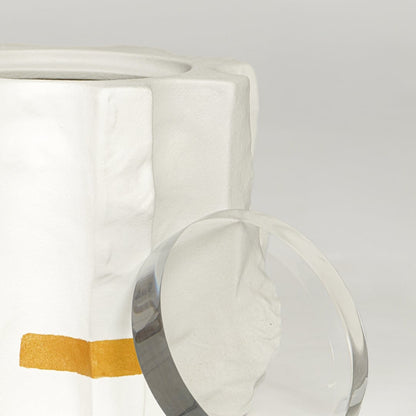 Close view of white ceramic vase with sculpted texture and gold accents highlighting premium finish and craftsmanship.