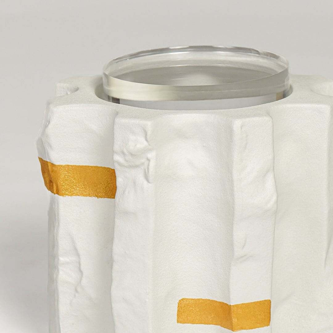 Detailed closeup of modern ceramic vase featuring matte white surface gold highlights and glass inner lining.