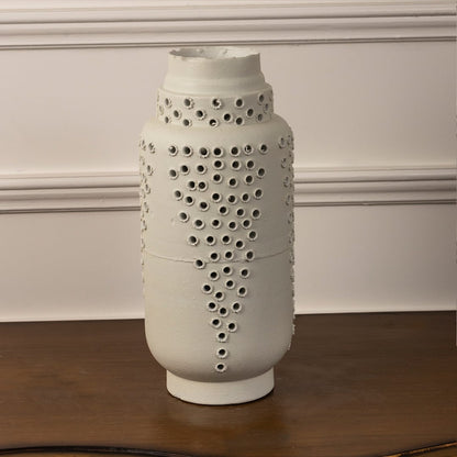 Minimalist tall white ceramic vase with perforated textured design ideal for shelf styling and modern home or office decor.