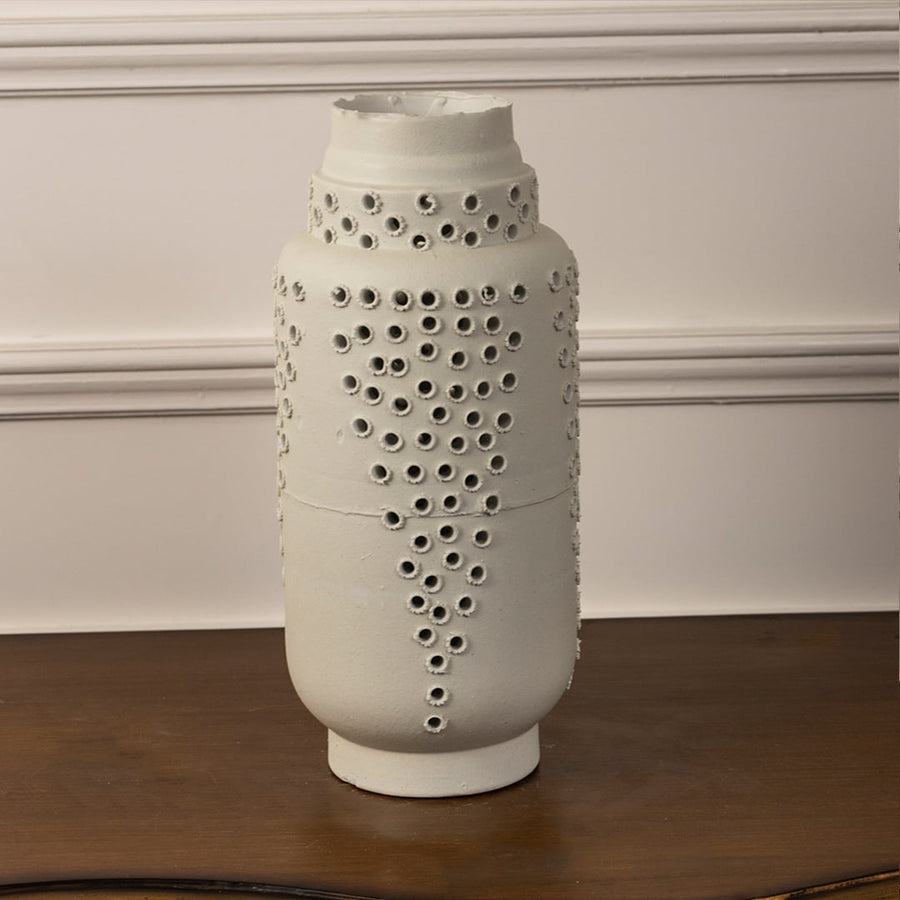 Minimalist tall white ceramic vase with perforated textured design ideal for shelf styling and modern home or office decor.