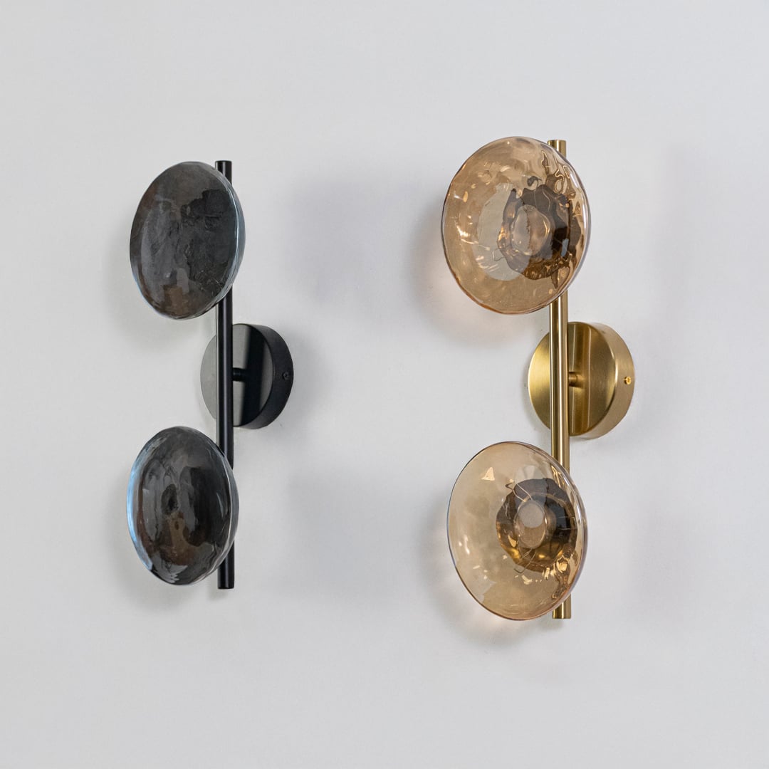 Gold double wall lights with amber textured glass globes shown on a bright white background with lights off for clarity.