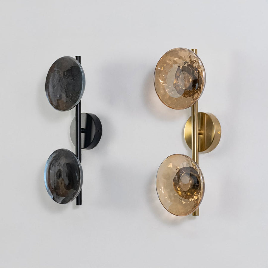 Gold double wall lights with amber textured glass globes shown on a bright white background with lights off for clarity.